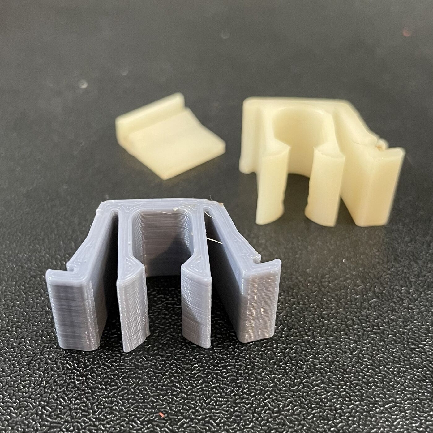 Replacement clip prototypes printed in several materials for fit comparison